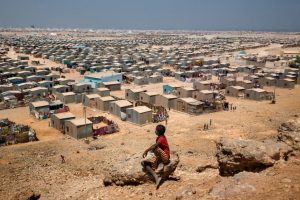 Africa, Somalia, Bosaso. 05/10/2015. Bosaso: the coastal city of 700,000 inhabitants. It is the main port of Somalia and it is the capital of Puntland; this macro-northern region, compare to the rest of the country, enjoys of a relative political and military stability. A kid look at the Buulo Mingis Settlement IDP camp.